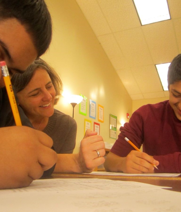 A volunteer math coach working with a student in class.
